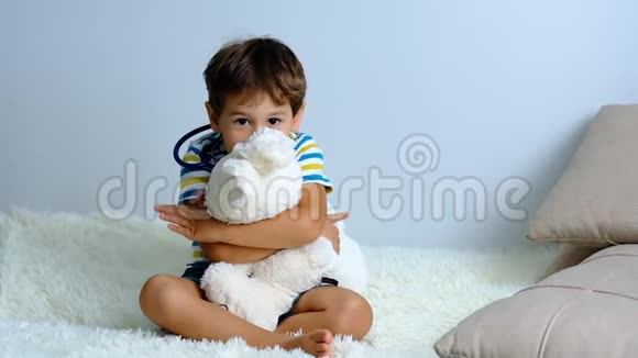 慢动作小男孩在家玩软玩具表现力强的小男孩拥抱她的毛绒朋友的肖像室内视频的预览图