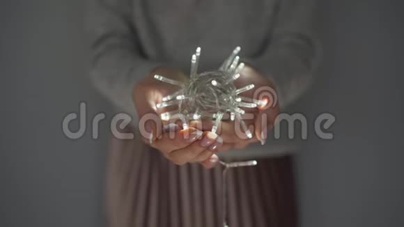 女人手里拿着白色的圣诞花环视频的预览图