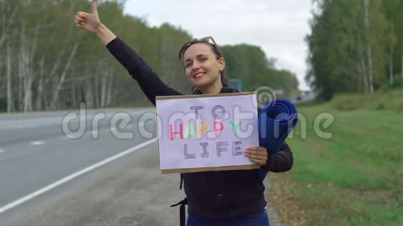 女人在路上骑自行车时拿着牌子视频的预览图