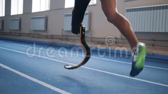 有仿生腿的运动员在跑道上慢跑侧视视频的预览图
