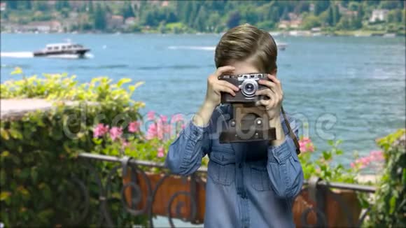 小男孩在海洋背景上使用胶卷相机视频的预览图