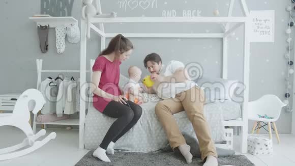 快乐的父母在卧室里玩女婴视频的预览图