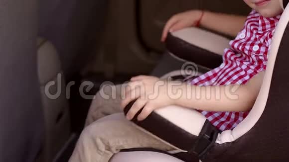 小孩坐在车里的座位上他双手抱在椅子的扶手上视频的预览图