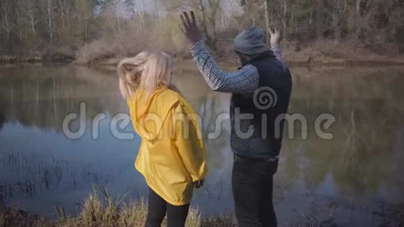 时髦的夫妇看着森林里的河流年轻夫妇在户外散步视频的预览图