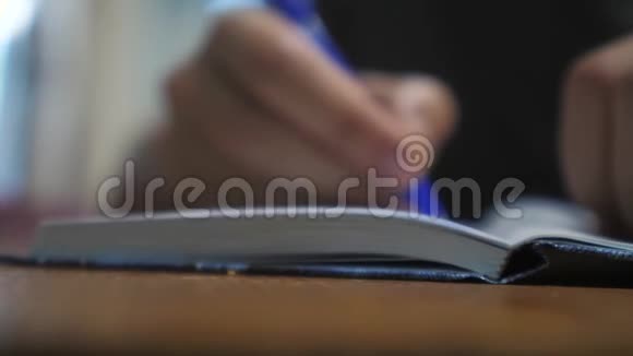 人在笔记本上写字男人手生活方式写在记事本上概念商业教育1男人在房间里做笔记视频的预览图