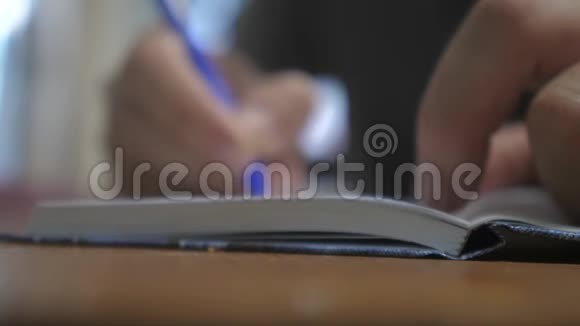 人在笔记本上写字男人手写记事本概念商业教育男人在笔记本上做笔记视频的预览图