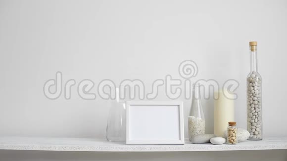 现代客房装饰与相框模型架子靠白色的墙壁装饰蜡烛玻璃和岩石手把手视频的预览图