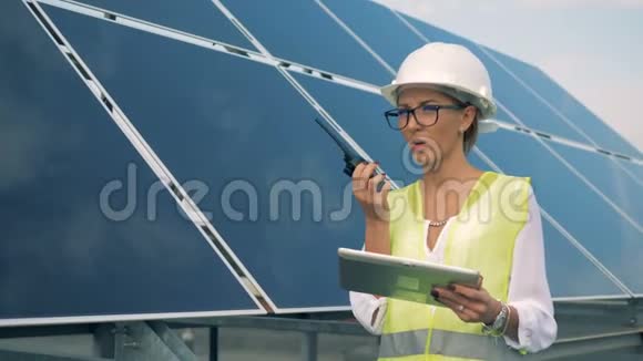 一名工人使用对讲机靠近太阳板关闭视频的预览图