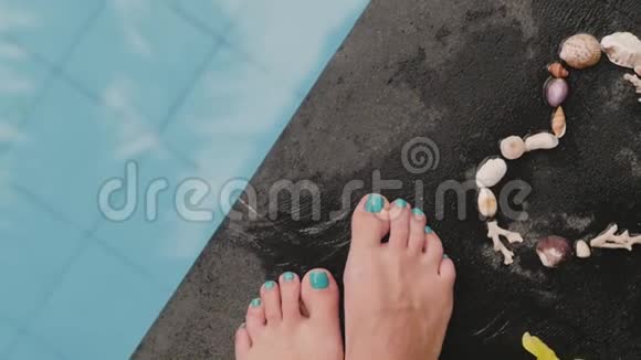 女腿靠近泳池特写海石和贝壳的心脏视频的预览图