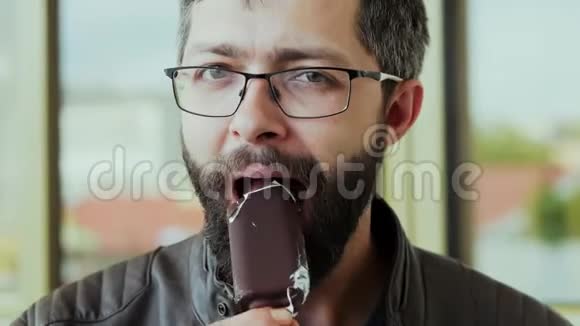 饥饿的大胡子男人吃巧克力冰淇淋的画像视频的预览图