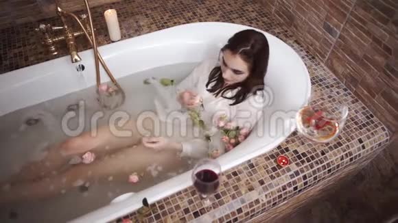 可爱的性感女人穿着白色衬衫洗澡水从水龙头里流出来可爱的女孩在浴室里享受视频的预览图