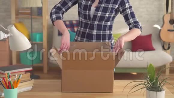 女人把孩子们衣服从盒子里拿出来搬到一个新家视频的预览图
