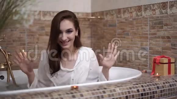 穿衬衫的漂亮女人在镜头前洗澡女士用手泼水视频的预览图