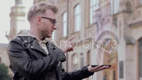 戴眼镜的聪明年轻人展示了一个概念全息图苹果视频的预览图