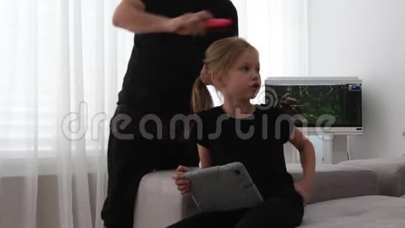 爸爸坐在沙发上梳女儿头发爸爸和女儿在一起视频的预览图