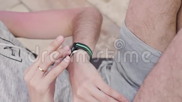 男性用手指轻触装有健身应用程序的智能手表屏幕视频的预览图