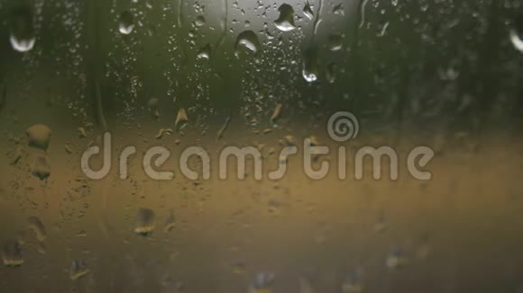 多云背景的窗户玻璃表面有雨滴雨滴的自然模式在雨中开车从这里看视频的预览图