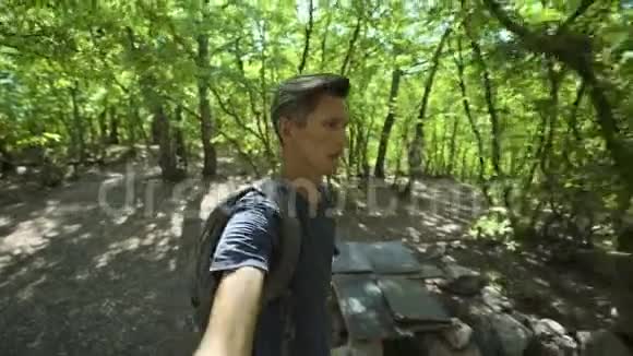 夏日在森林中快速行走的年轻人特写广角自拍视频的预览图