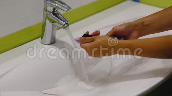 慢动作木刷女人在洗手池里用肥皂和泡沫洗脏化妆刷视频的预览图