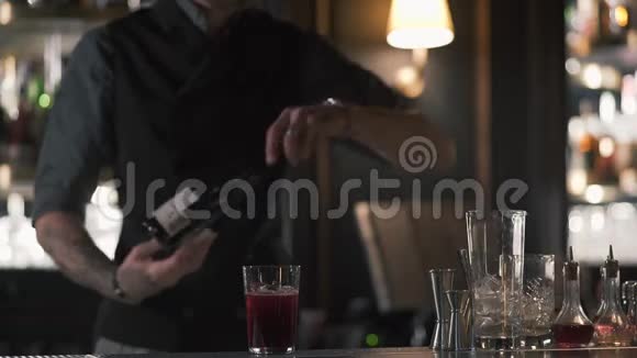 一位专业的酒保站在酒吧柜台前打开一瓶香槟或起泡葡萄酒视频的预览图