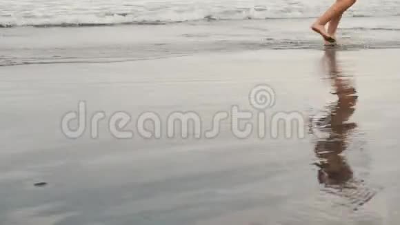 追踪在加那利群岛特内里费的黑色沙滩上慢跑的迷人年轻女子的照片多云的女性视频的预览图