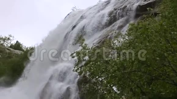 在一片绿色的森林中一个暴风雨的河流瀑布在缓慢的运动中的近距离水滴和喷雾并跟踪视频的预览图