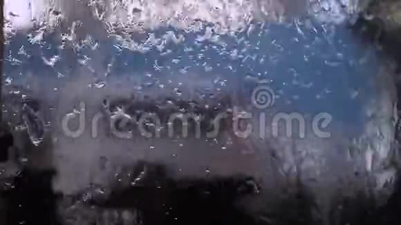在模糊的背景上滴在汽车玻璃上的水视频的预览图