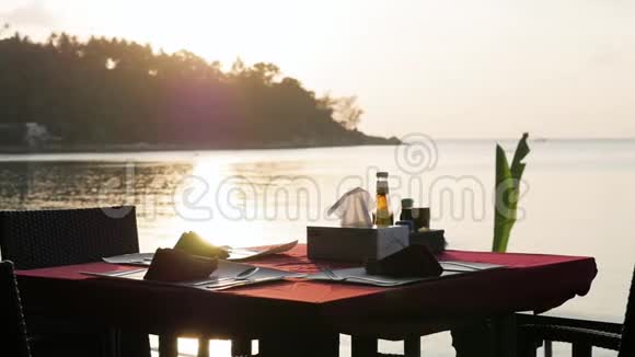 在海洋上的餐厅提供餐桌服务以期待日落时的游客视频的预览图