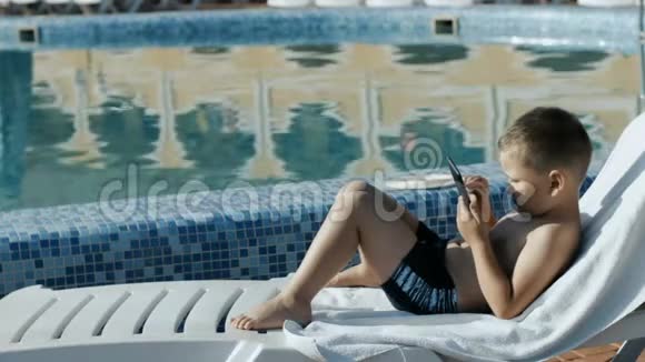 在游泳池附近休息的男孩视频的预览图