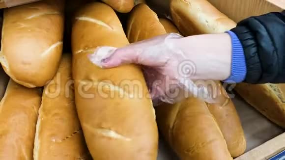 年轻女子在超市里选择面包在商店里挑选面包的女性手的特写镜头视频的预览图