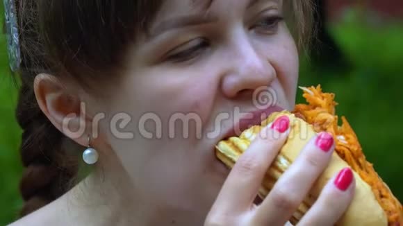女孩在公园里快乐地吃热狗视频的预览图