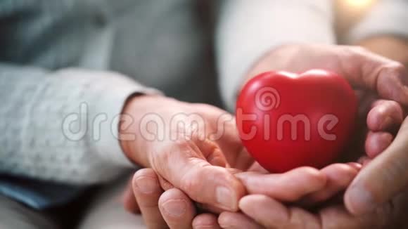 年长夫妇双手呈红色心形视频的预览图