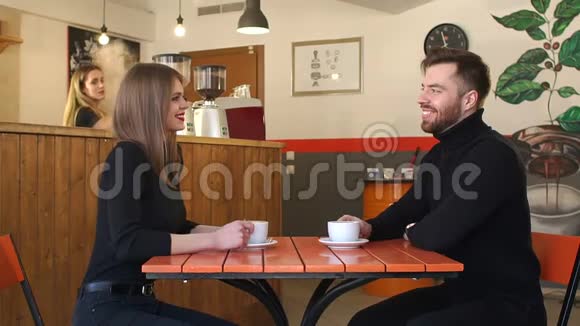 一对夫妇在咖啡店第一次约会时喝咖啡慢动作视频的预览图