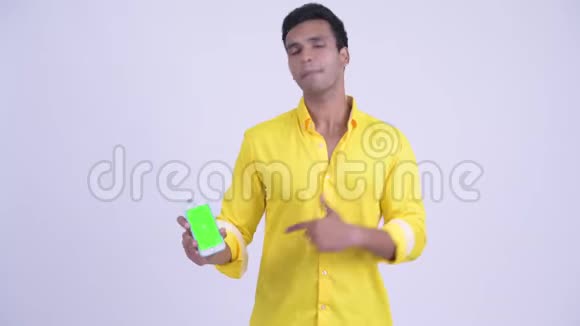 快乐的年轻印度商人带着电话和大拇指视频的预览图