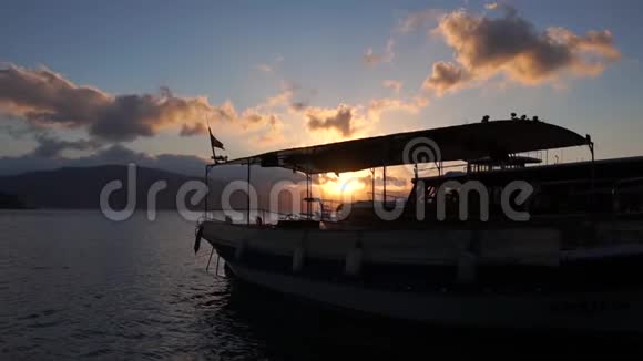 日落时分海上一艘美丽的大船的剪影视频的预览图