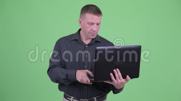 一个成熟的商人在用笔记本电脑思考视频的预览图
