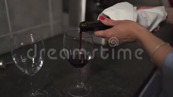 女人把红酒倒进酒杯里凑近两杯空酒杯视频的预览图