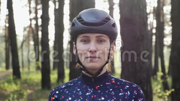 年轻漂亮的女孩戴上自行车眼镜戴着头盔和蓝色球衣公路自行车概念慢动作视频的预览图