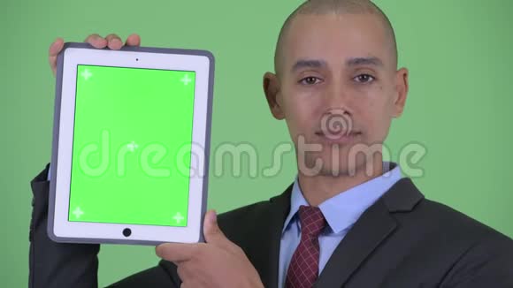一张展示数码平板电脑的快乐秃顶多民族商人的脸视频的预览图