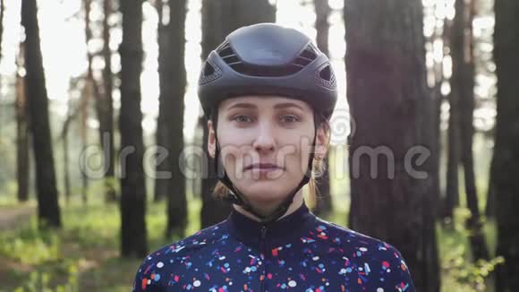 年轻漂亮的女孩戴上自行车眼镜戴着头盔和蓝色球衣公路自行车概念视频的预览图