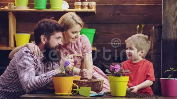 可爱的孩子帮助他的父母照顾植物春观念自然与关怀幸福的家庭种花家庭视频的预览图
