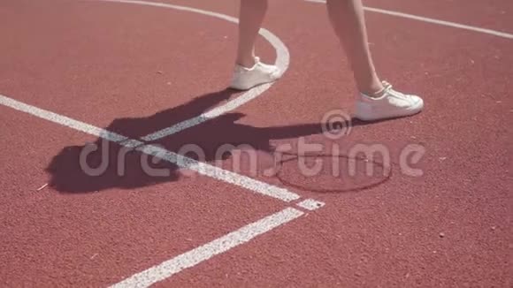 穿白色运动鞋的女人在球场上打网球前做热身运动的腿影子重复着运动视频的预览图