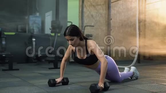 运动的黑发女人在健身房锻炼时推起来视频的预览图