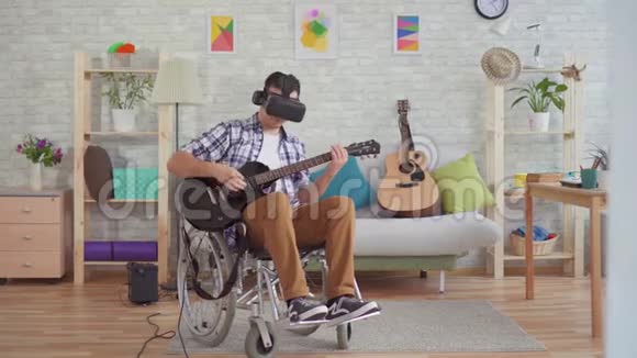 虚拟现实中轮椅残疾人的年轻人眼镜音乐家弹电吉他视频的预览图