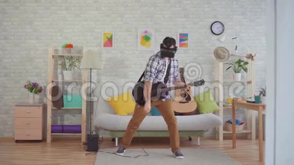 虚拟现实眼镜中的年轻音乐家有感情地弹电吉他视频的预览图