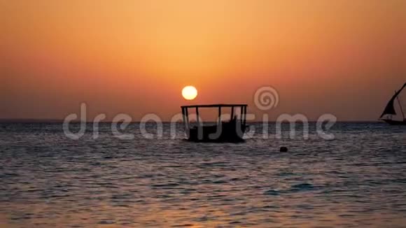 热带海洋日落大红太阳和渔船剪影视频的预览图