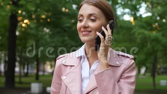 公园里的一位年轻女子在讲移动电话视频的预览图