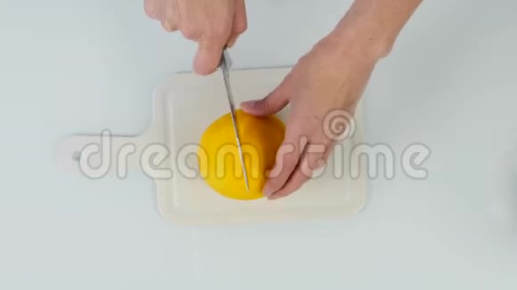 用刀切橘子的糖果师切板上两半橘黄色4K顶视图视频的预览图