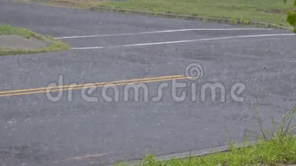 雨水滴在沥青上的水坑里由于雨季的大雨雨水淹没了道路上的洪水视频的预览图