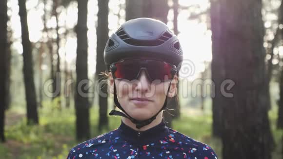 漂亮的年轻白种人女人戴着黑色头盔和运动衫戴上自行车眼镜铁人三项的概念慢动作视频的预览图